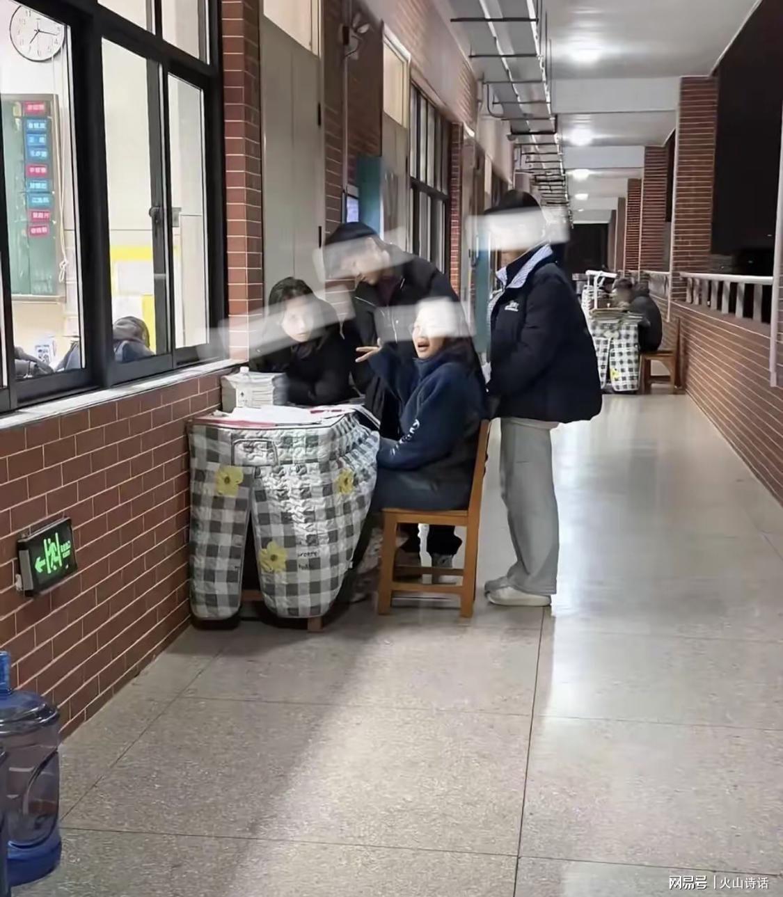 震惊！网传有学校老师冬天坐在教学楼走廊，批改作业并为学生解答